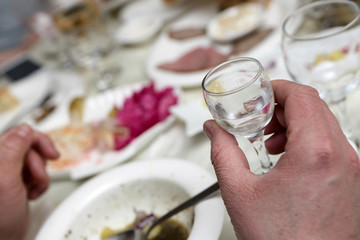 Person holding glass of vodka