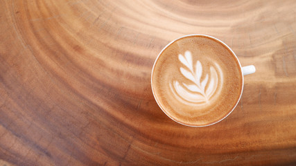 Top view of hot coffee latte art on wood table background