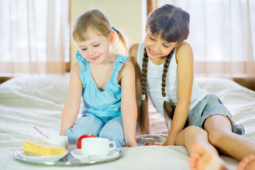 two sisters having breakfast in bed