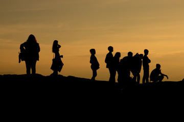 Fototapeta na wymiar silhouette of people relax at the cliff and mountains with sunset in the evening
