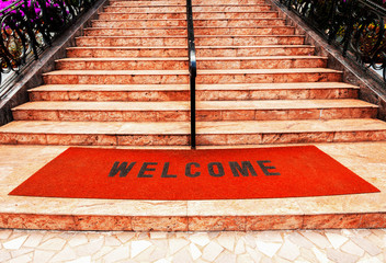 welcome plastic red carpet in front of the marble staircase at the hotel