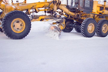 Clearing snow. Tractor snow plow clears the street of snow