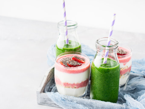 Healthy food concept green smoothie yogurt strawberries chia seeds breakfast on white gray tray blue textile. Fruit Vegetable juice glass bottle