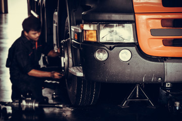 automobile mechanic checking truck in the garage, selective focus and film style.