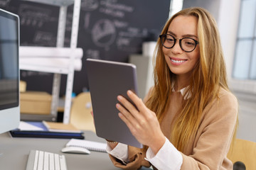 junge frau im büro arbeitet am tablet