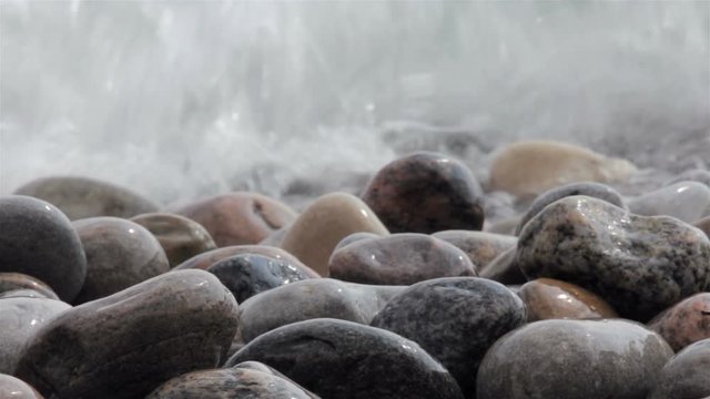 waves crash over a rocky beach closeup