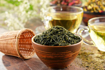 Composition with cup of tea and bowls of tea leaves