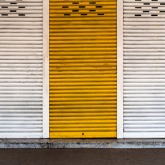 Old white and yellow roller shutter door