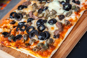 Mushroom pizza with mushroom cheese and tomato, on a wooden board.