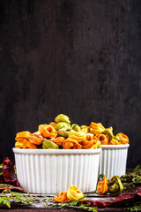Naklejka premium Raw italian pastani tortellini with flour in white plate on black wooden background, place for text