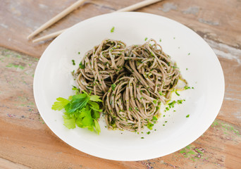 Organic brown noodles cooked in garlic oil, fresh coriander and sea salt. Served wit chopsticks on a whim plate.