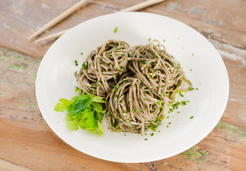 Organic brown noodles cooked in garlic oil, fresh coriander and sea salt. Served wit chopsticks on a whim plate.