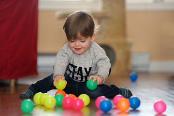 Fototapeta na wymiar Young boy playing with plastic balls