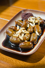 Spicy pan fried mini chicken sausages, served with a thick sweet and spicy sauce, and pine nuts.
