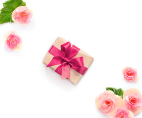 gift box with red ribbon and bow on white with flowers background. flat lat, top view