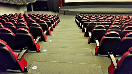 Rows of red plastic seats in empty cinema hall