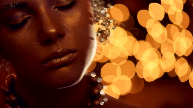 Fashion art golden skin woman face portrait closeup. Glamour shiny professional makeup. 4K UHD video