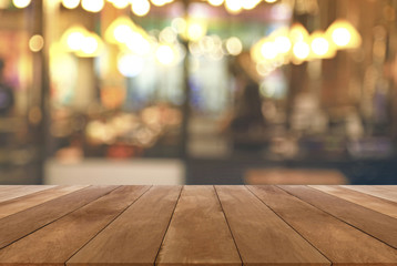Wood table top with blurred light cafe or restaurant background 