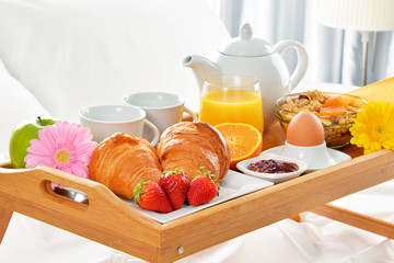 Breakfast tray in bed in hotel room