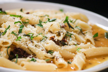 Penne pasta with cheese, tomato and sauce.