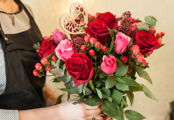 Fototapeta na wymiar Florist at work, gathers a bouquet. Hands close-up. Wedding preparations.