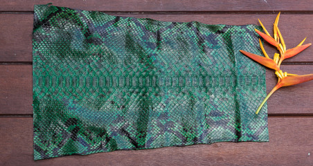 Python snakeskin leather, python skin. Small piece on a wooden background.