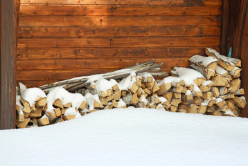 Chopped and stacked birch firewood covered with snow