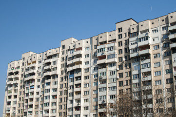 Fototapeta na wymiar Large obsolete suburban apartment building in clear sunny day