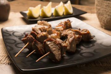 Plate of shish kebab grilled on wooden skewers 