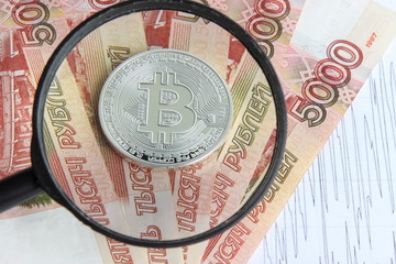 Fototapeta na wymiar silver bitcoin on the background of Russian banknotes