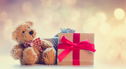 cute teddy bear and beautiful gifts on the fairy lights bokeh background