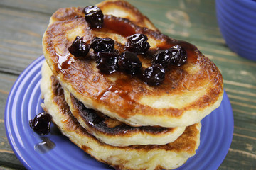 delicious pancakes with cherry jam on a blue plate