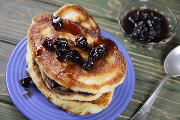 delicious pancakes with cherry jam on a blue plate