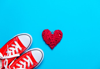 big red gumshoes and beautiful heart shaped toy on the wonderful blue background