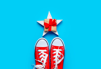 big red gumshoes and beautiful gift on star shaped toy on the wonderful blue background