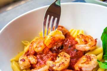 Italian food pasta pennes with shrimp and tomato sauc