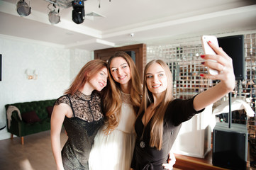 Fototapeta na wymiar Three young girls are doing selfie photo in a restaurant