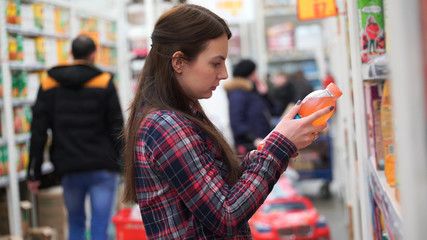 woman buys juice in supermarket or store.
