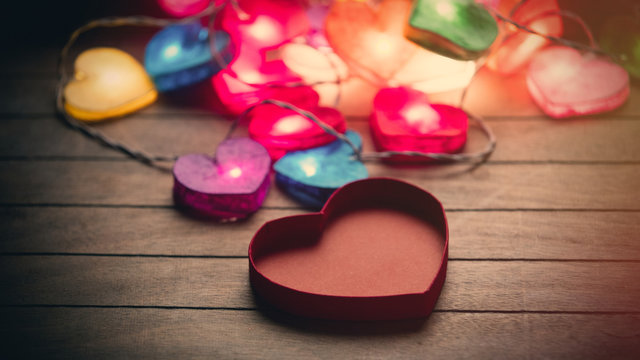 beautiful colorful heart shaped garland and opened heart shaped box on the wonderful brown wooden background
