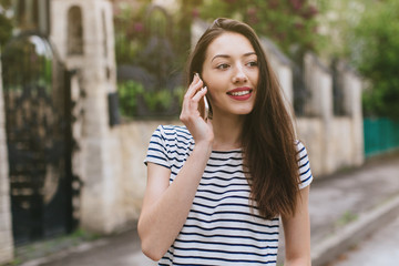 Beautiful stylish and fashionable girl calling in the street.