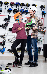 Father putting roller-skates on his son
