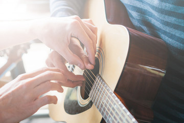 Masterclass learning to play the guitar outdoors. Musical education.