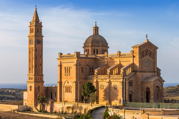 Gozo, Malta - The Basilica of the National Shrine of the Blessed Virgin of Ta' Pinu at sunset with clear blue sky on a summer day