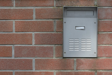 metallic mailbox on brick wall
