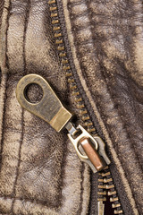 Close-up zipper on old brown leather jacket. Focus on zipper