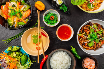 Asian food served on black stone, top view