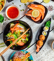 Asian food served on wooden table, top view