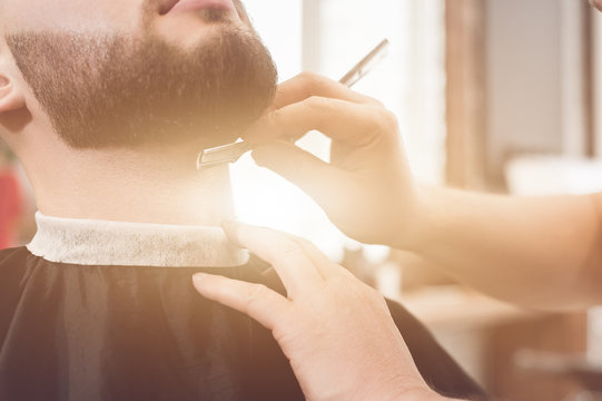 Shave the beard in the barbershop. shaving with a straight razor