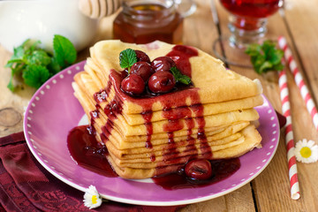 Stack of thin crepes with cherry topping