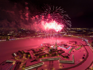 Aerial view of Fireworks over the Peter and Paul Fortress, Palace bridge, Old Stock Exchange, Winter Palace, night illumination, river Neva as mirror, snow